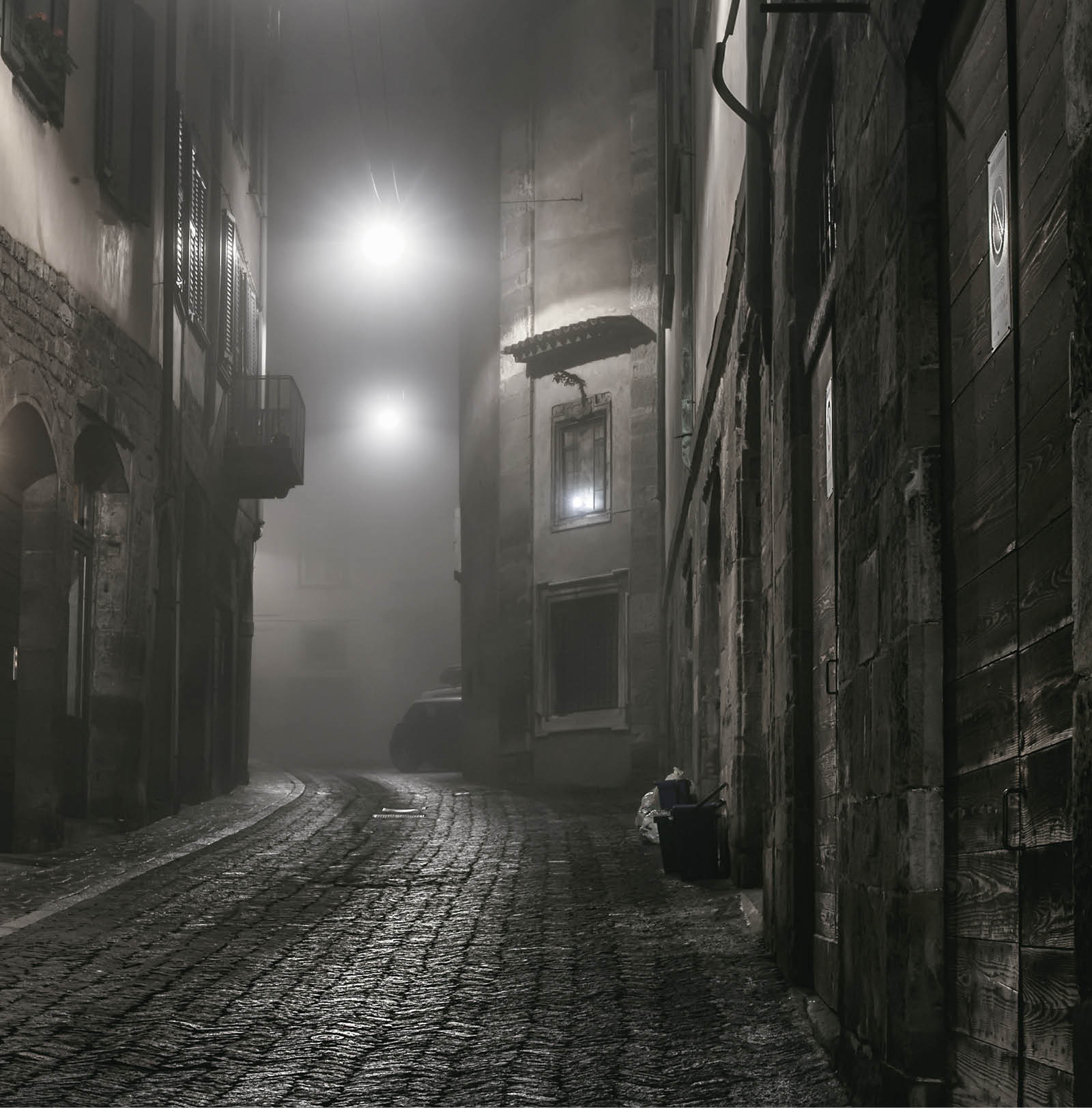 Old European narrow empty street of a medieval town on a foggy evening  Taken in Bergamo, Citta Alta
