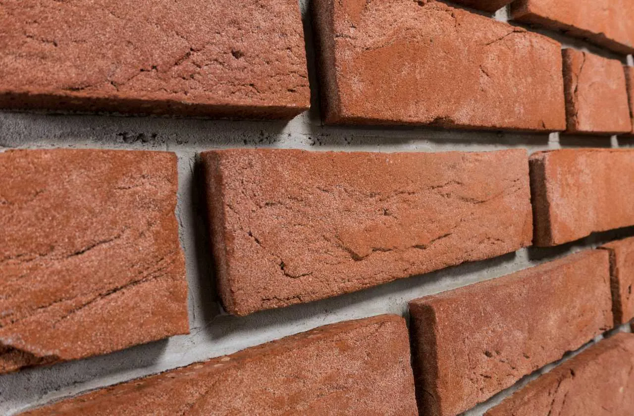 Produktbild schräg Klinkerriemchen Rubinrot. Riemchen aus einem schönen, hellen, klaren Rotton mit feinem hellen Sand versehen und einer leicht genarbter Oberfläche. Klassisch, freundlich