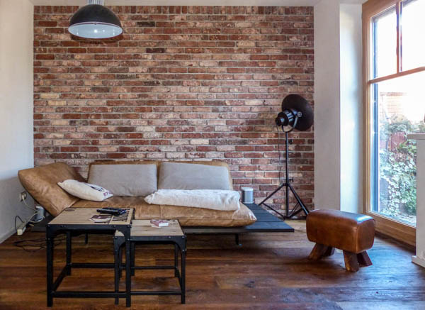 Antik-edel-Wohnzimmerwand Couch vor einer Wohnzimmerwand mit den Backsteinriemchen Antik edel