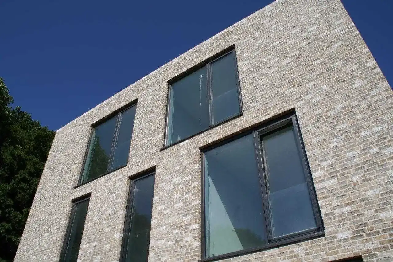 Modernes Bürogebäude mit dunklen Fenstern und der Steinsorte Irish moor