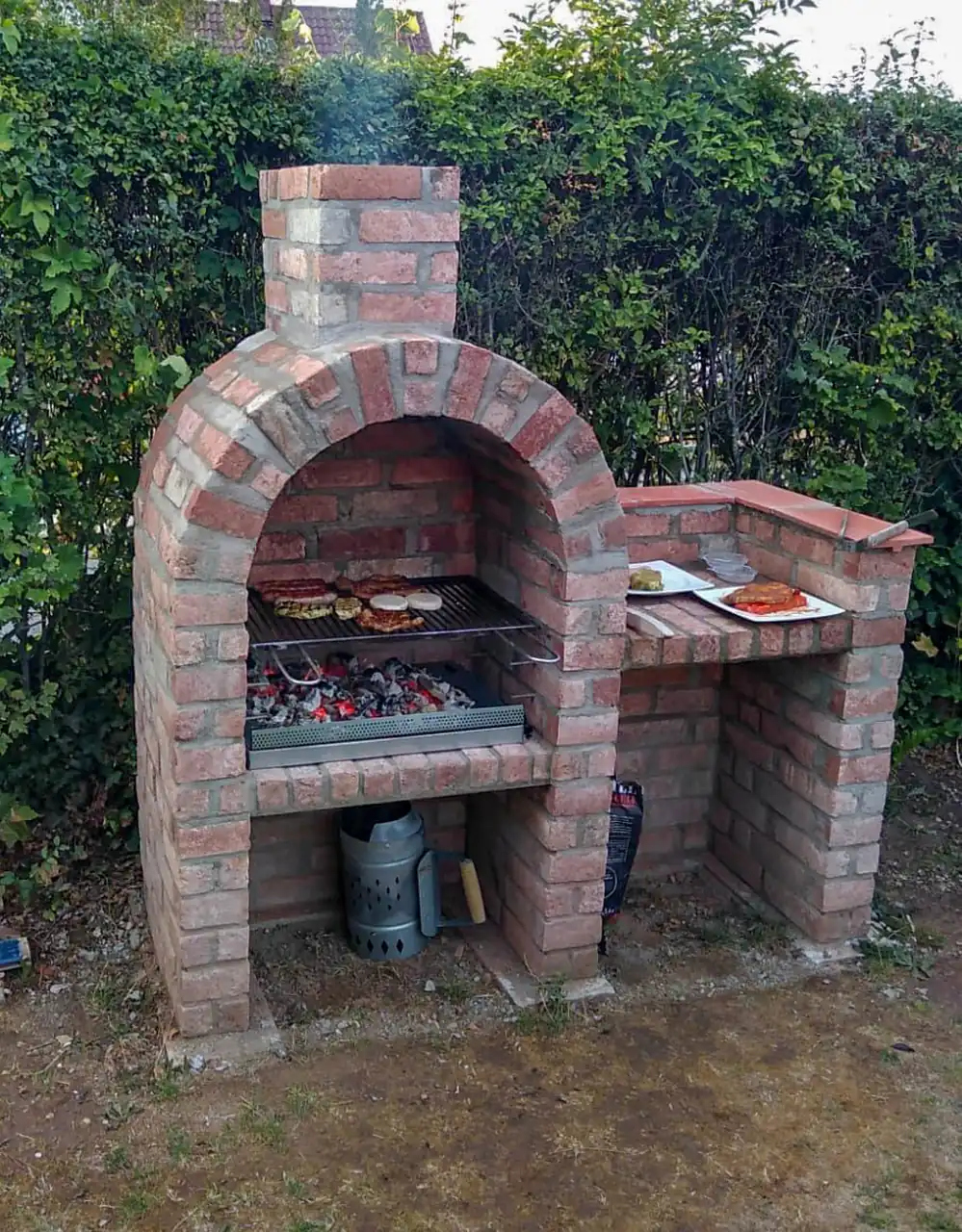 Gemauerter Grill aus Klinkermittelstücken in einem Garten