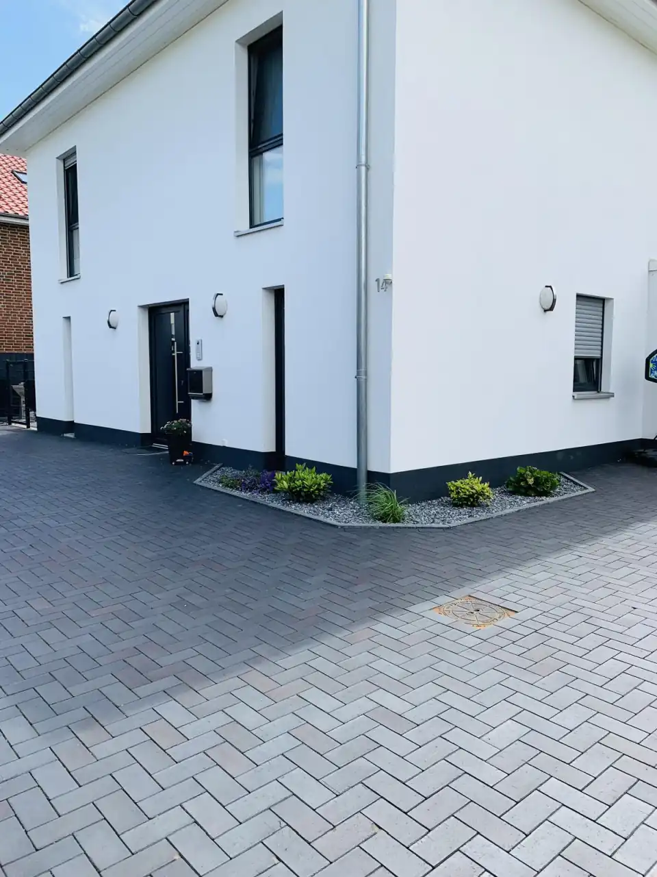Modernes weißes Einfamilienhaus mit Hofeinfahrt in schwarzen Pflasterklinker Dresden