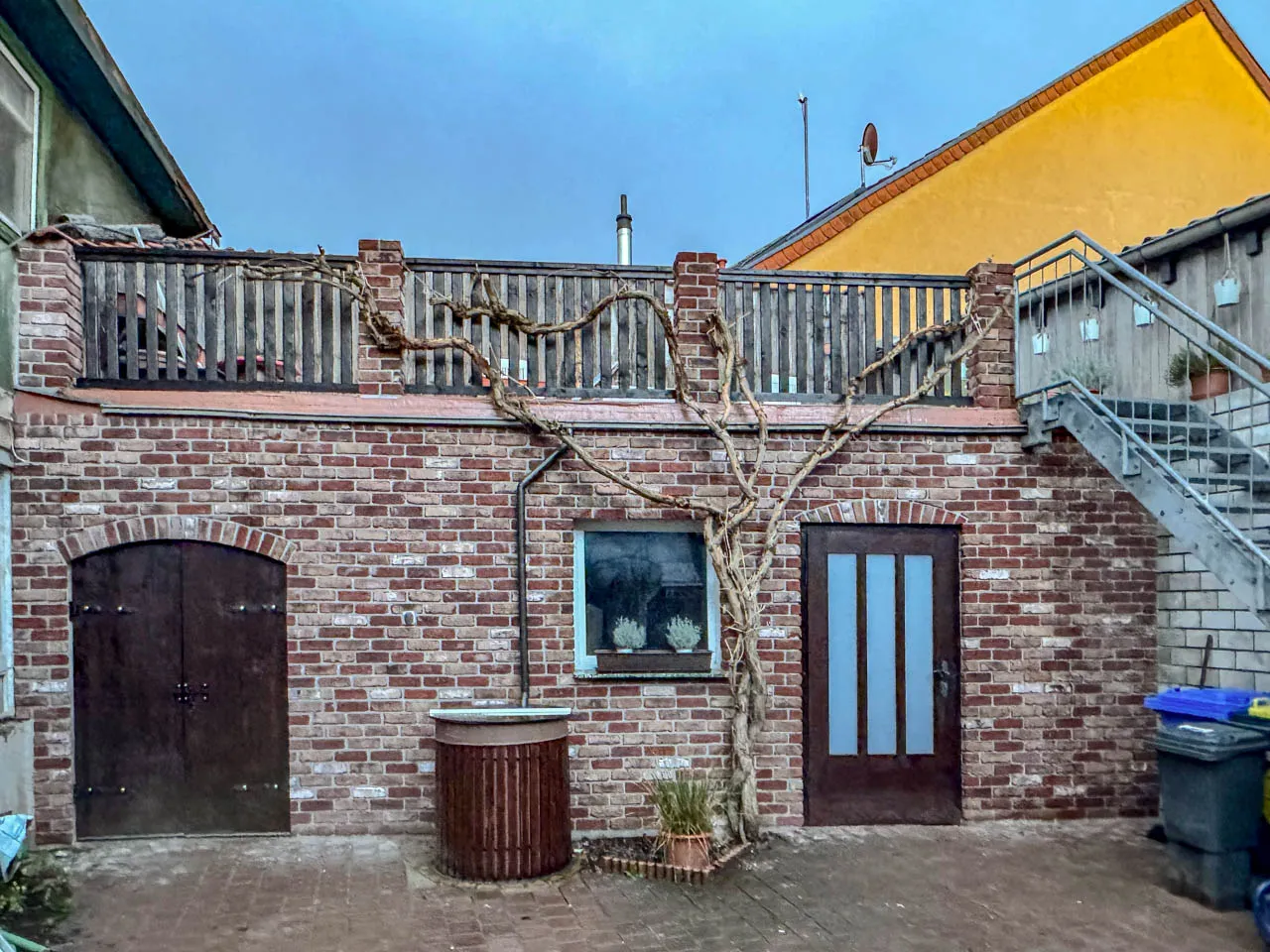 Innenhof Mauer mit Weinrebe und Gelaender Backsteinriemchen Antik historisch bunt