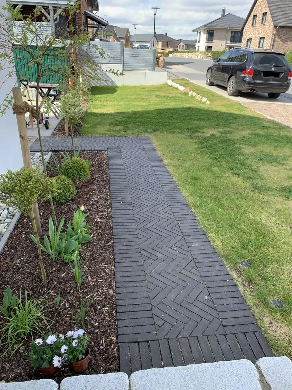 Kleiner Gehweg im Garten im Fischgrätmuster verlegt