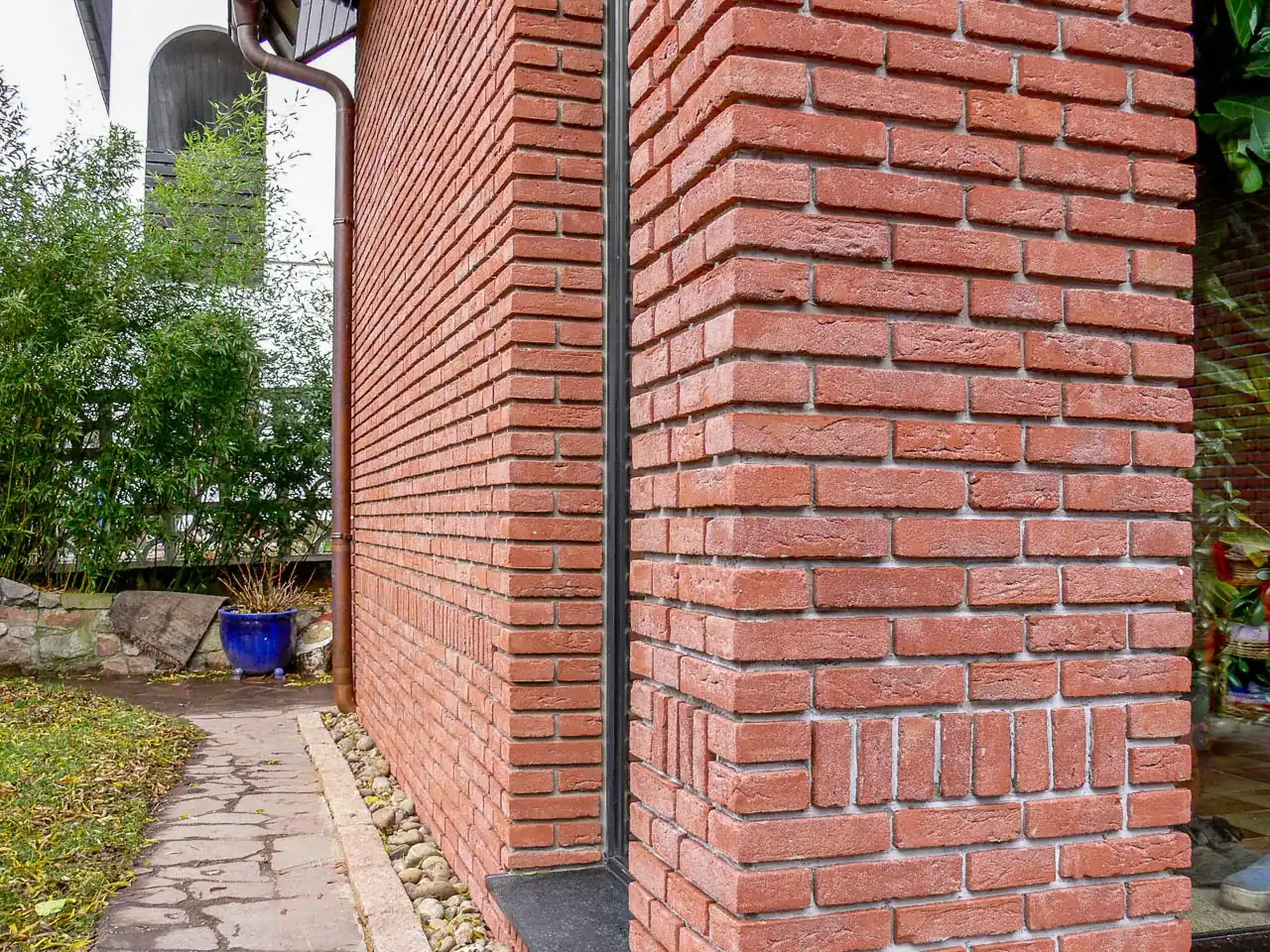 Runbinrot an einer Säule außen und Hauswand