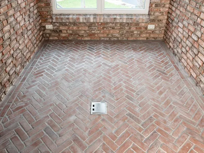 Ansicht eines Bodens auf dem rote Riemchen in einem Fischgrätmusterverlegt sind