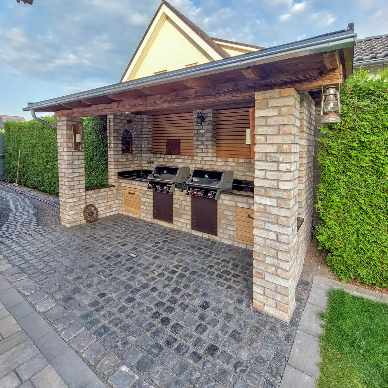 Eine schöne Outdoorküche, verklinkert mit den tollen Backsteinriemchen der Sorte Irish Moor. Das leicht rötlich schimmernde Riemchen passt gut zur Dachunterkonstruktion aus Holz
