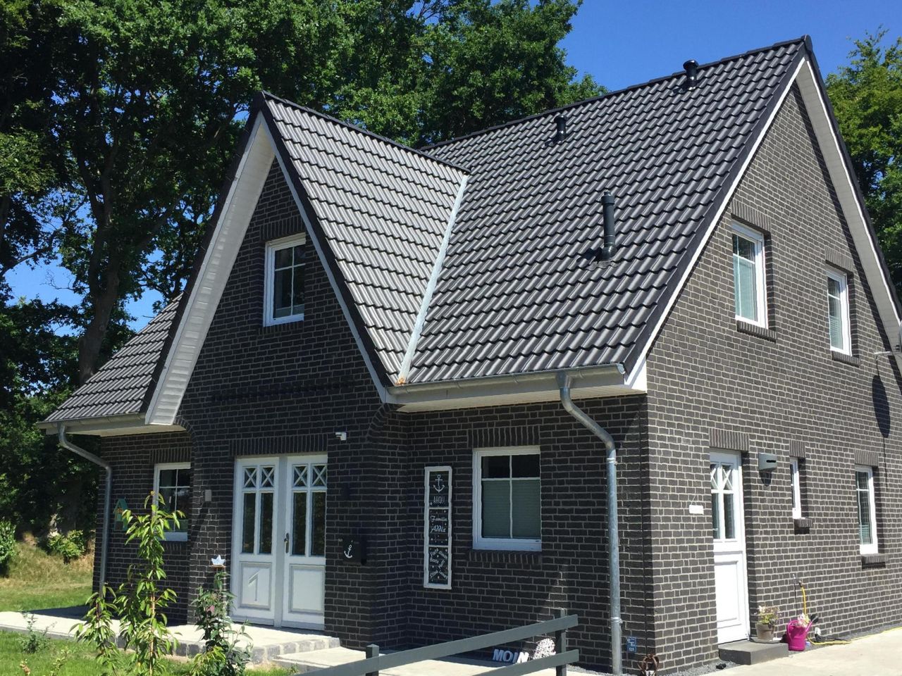 Haus mit schwarzen Klinkerriemchen und weißen Fenstern