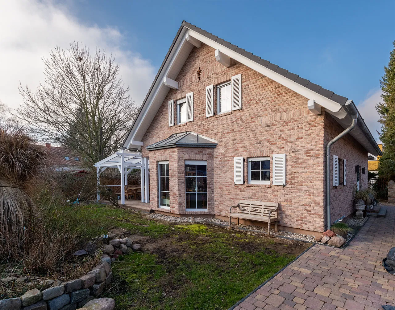 Klinkerhausfassade mir roten Ziegelriemchen der Sorte Antik edel. Das Haus wirkt durch die helle Fugenfarbe freundlich und hell im klassisch edlen Rot