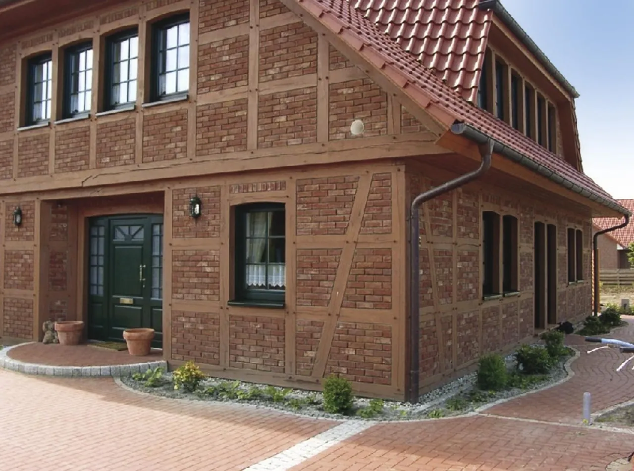 Haus auf einem Hofgut mit Exquisit rot und Fachwerk kombinierter Fassade