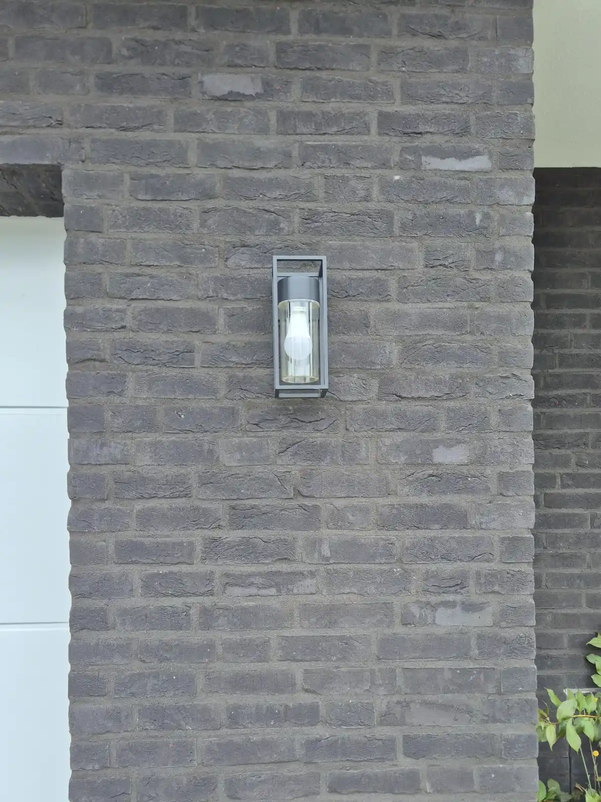 Schwarze Klinkerwand mit Außenlampe