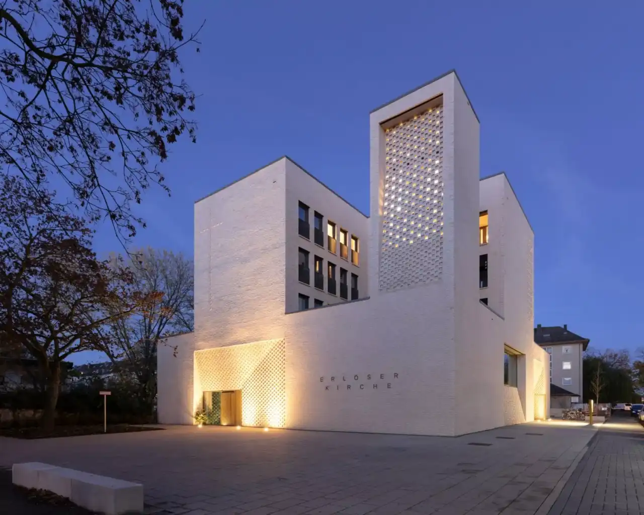 Gebäudekomplex mit Hausfassade in gelb-weiß mit indirekter Beleuchtung vom Boden aus