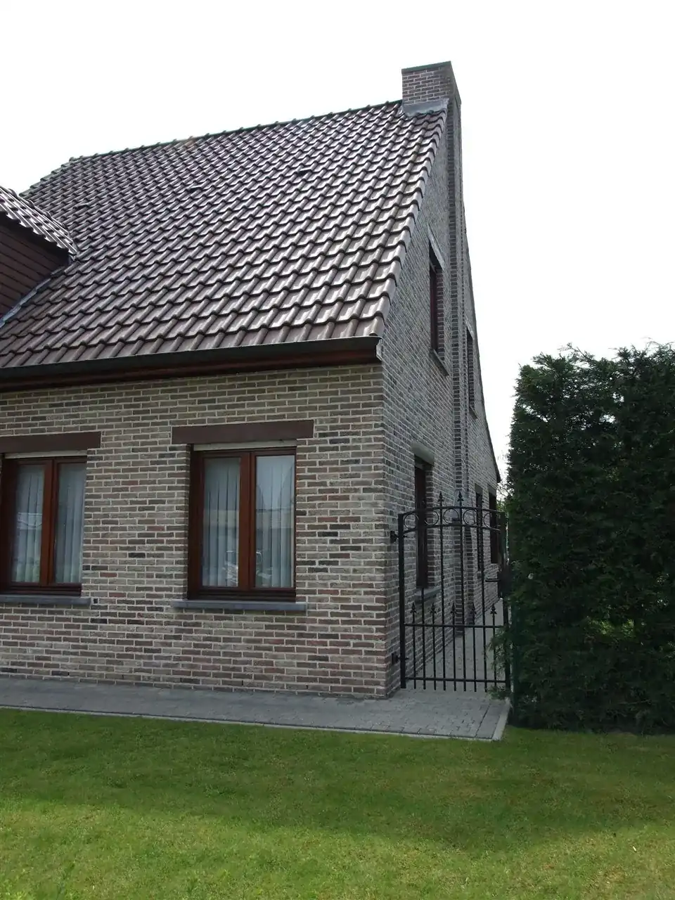 Wohnhaus mit dunklen Fenstern und Klinkern in rot schwarz weiß
