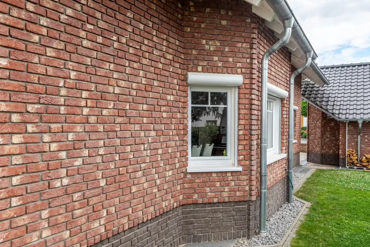 Erker an einem Haus mit Klinkersteinen Neu römisch und dunklem Sockel