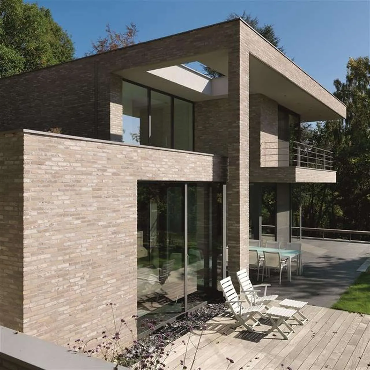 Sehr moderner Baustil. Flachdachhaus mit beiger Außenfassade. Klinkerriemchen der Sorte Antik vintage ist hier Programm. Die Fassade wirkt im licht mehr beige und passt toll zur holzterrasse