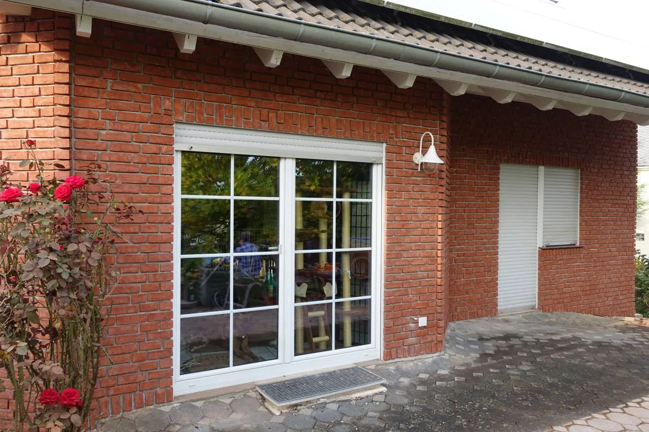 Klassisch rotes Klinkerhaus mit weißen Fenstern. Die Sorte Rubinrot wirkt hier im freundlichen, einladenden Rotton ganz klassisch und zeitlos