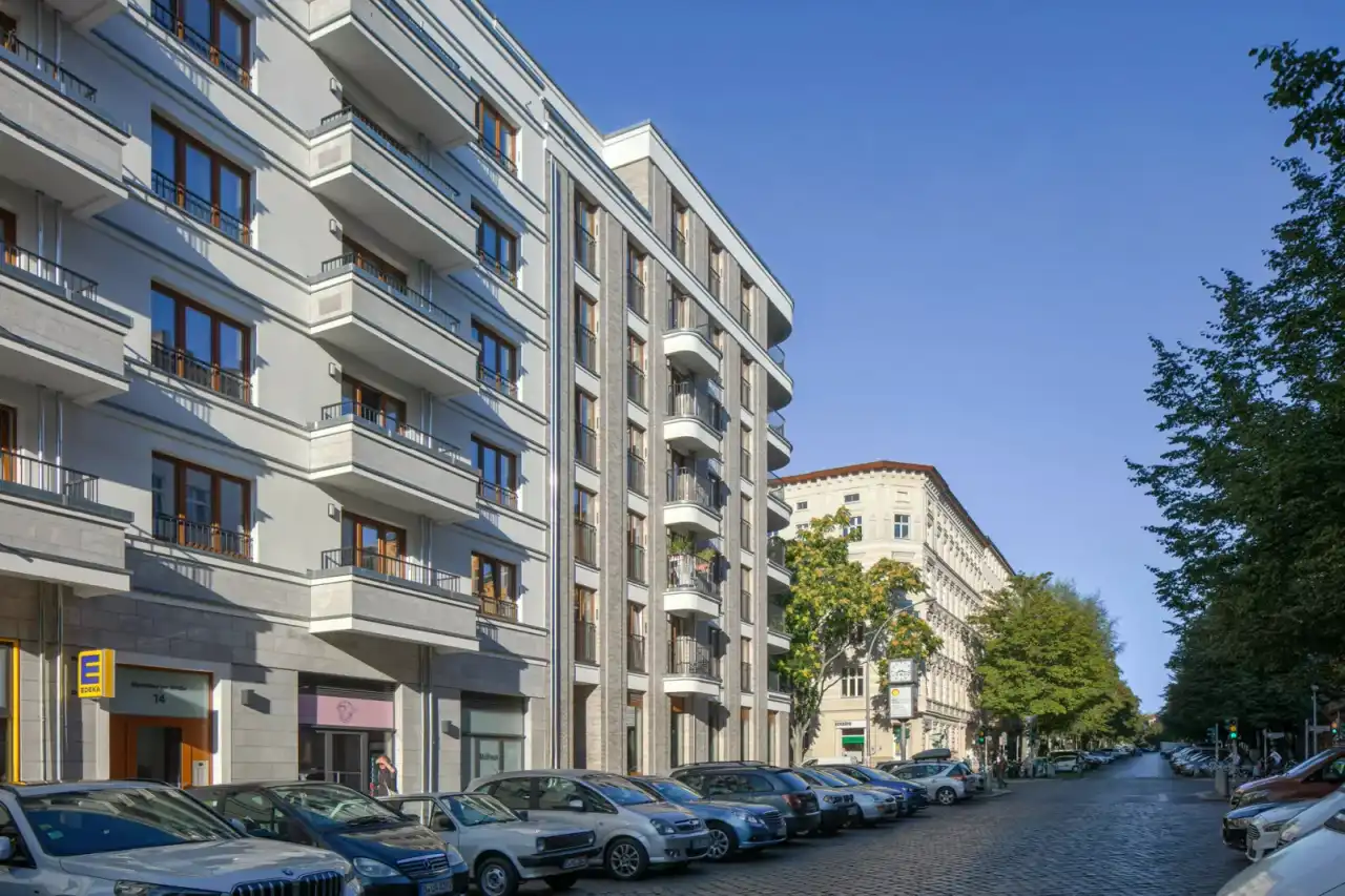 Mehrfamilienhaus mit Balkonen und grau-weißer Riemchenfassde