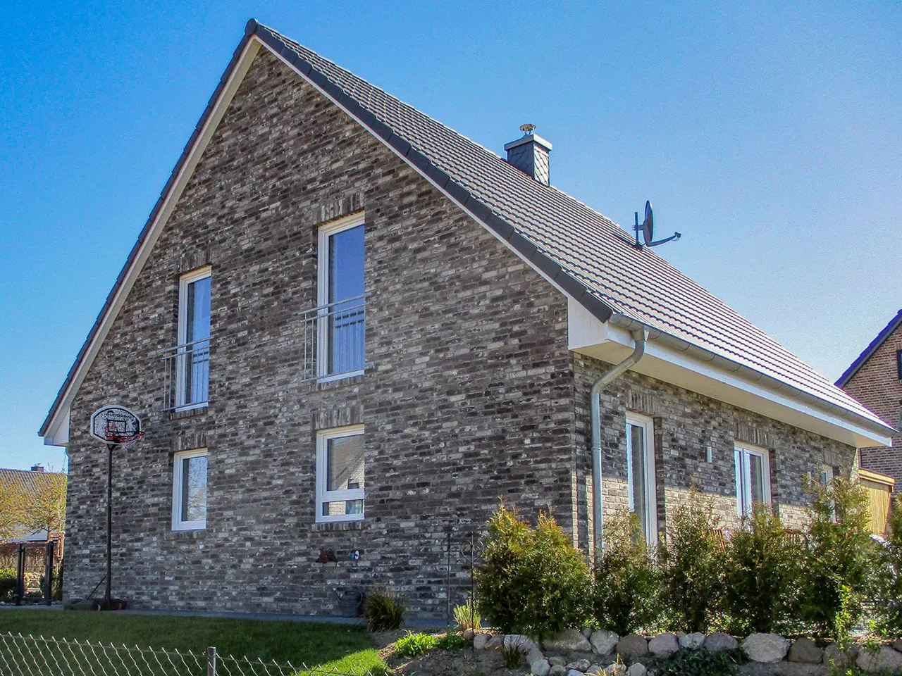 Ganze Hausfassade mit der Sorte Retro shadow. Eine moderne, dunkle Fassade aus grauen und schwarzen Backsteinriemchen.