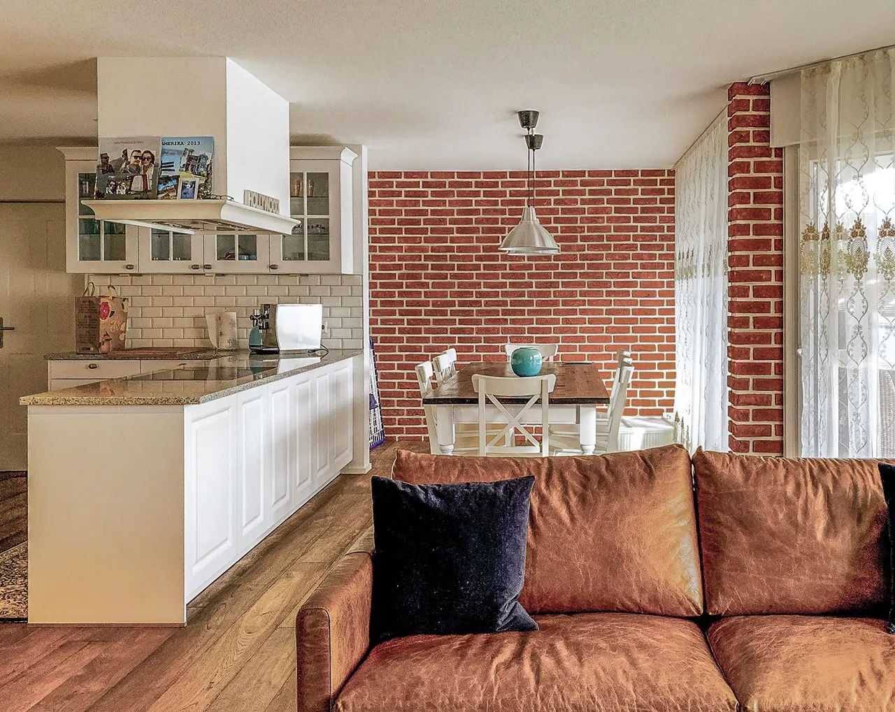 Schöne, klassische Esszimmer-Klinkerwand, weiß verfugt mit offener Küche in weiß gehalten.Die Wand passt perfekt zu de weißen Stühlen und dem Holztisch. Eine strahlend rote Wand mit leicht schwarzer Besandung