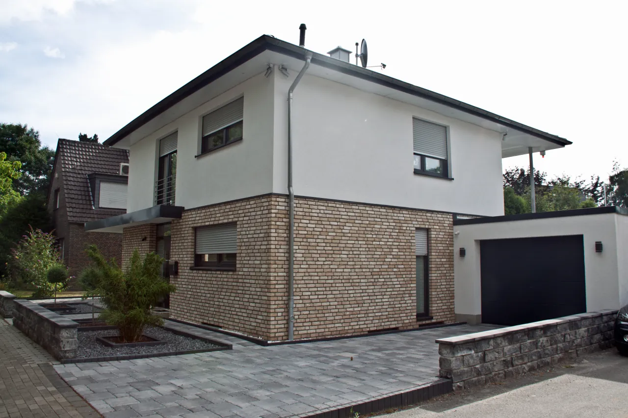 Wohnhaus mit Antik gelb als Fassade im Erdgeschoss und weißem Putz im Obergeschoss
