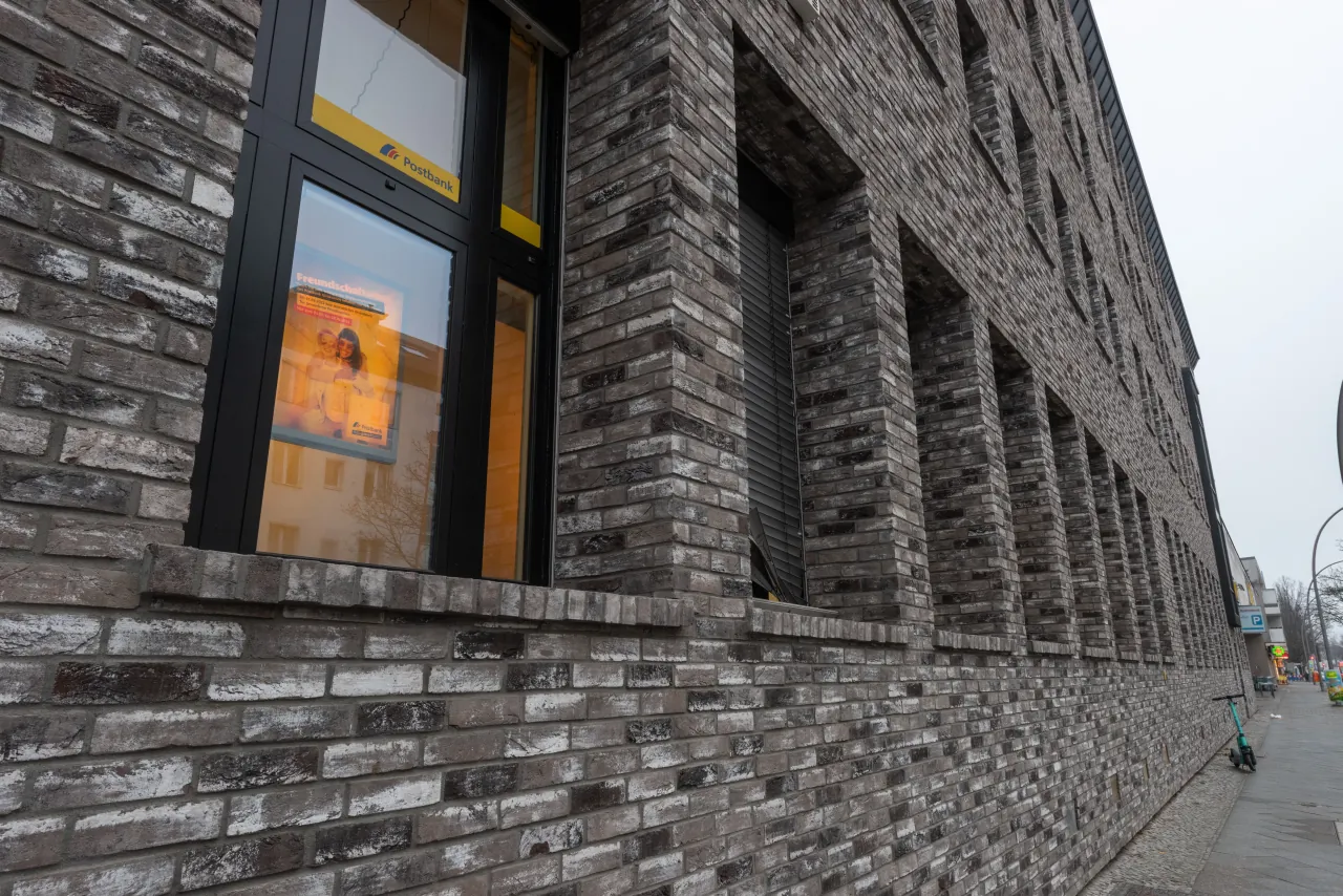 Schrägbild einer Hausfassade mit großen Fenstern und den Riemchen Retro grizzly und Retro shadow