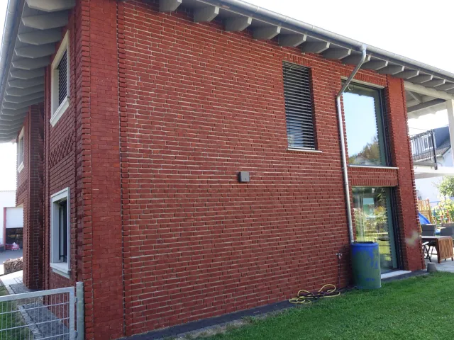Eine klassische rote Hausfassade mit WDVS und roten Klinkerriemchen.