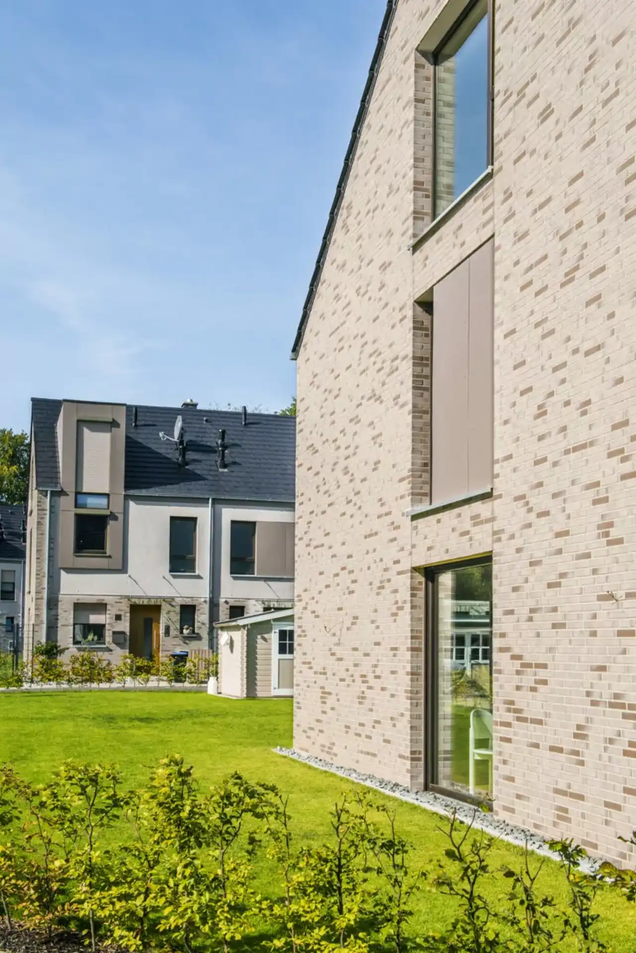 Seitenansicht eines Einfamilienhauses mit Fassade aus grauen Riemchen