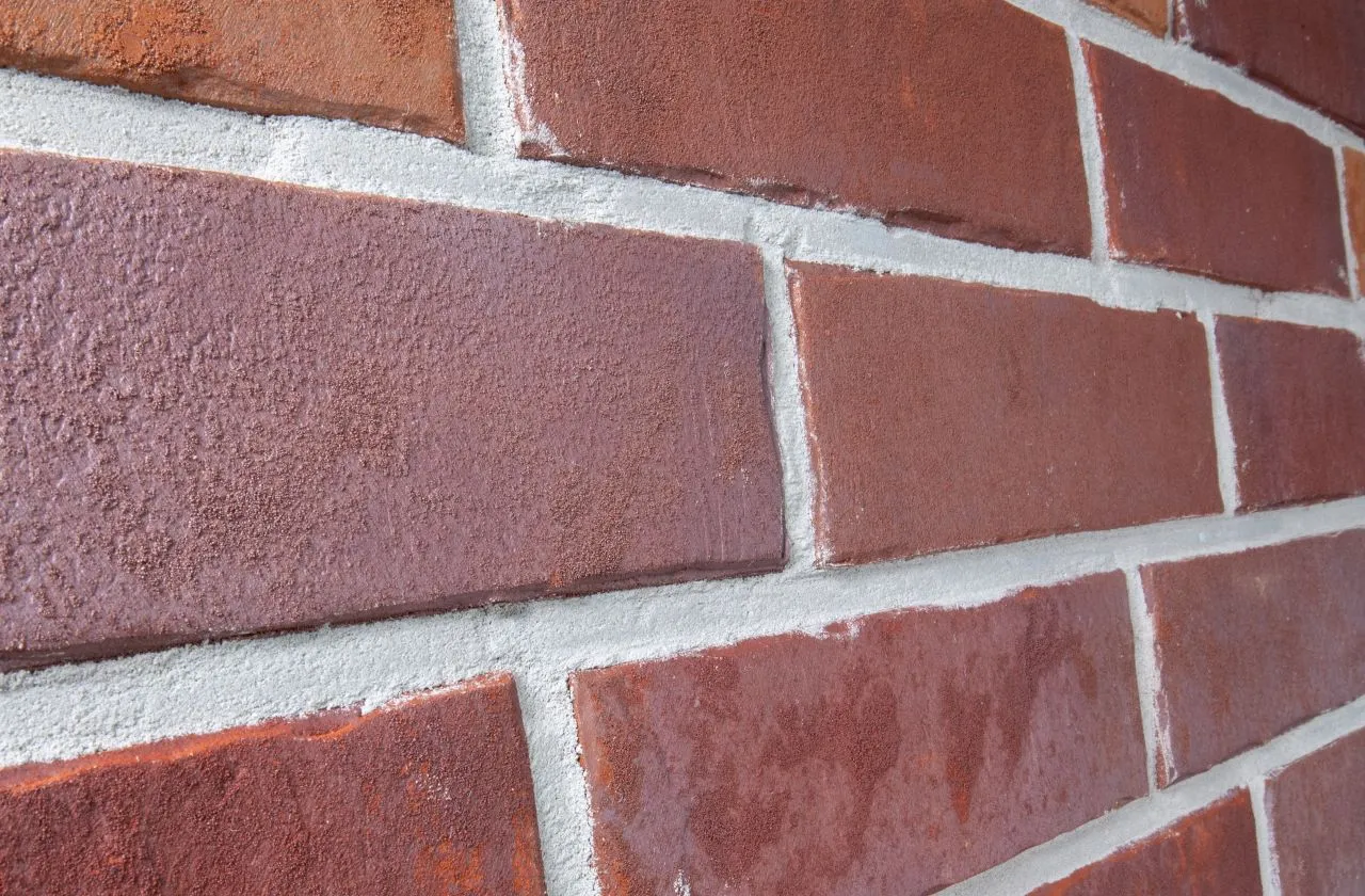 Spaltriemchen Kupfer rot-bunt Produktbild schräg Spaltriemchen Kupfer rot bunt. Das Klinkerriemchen hat eine glatte rot-bunte Oberfläche und ist nur 14mm stark.