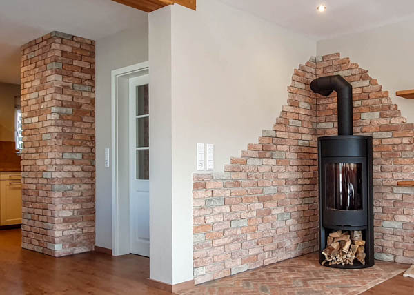 Klinkerriemchen-Ofen-Antik-edel Kamin in einem Wohzimmer und der Riemchensorte Antik edel als feuerfeste Kaminrückwand