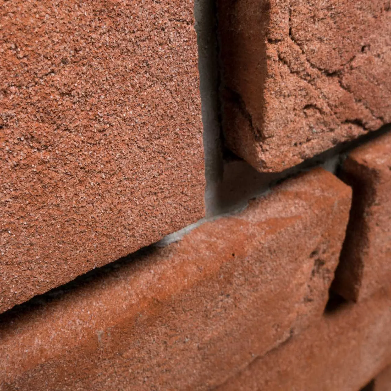 Produktbild schräg im Detail Klinkerriemchen Rubinrot. Riemchen aus einem schönen, hellen, klaren Rotton mit feinem hellen Sand versehen und einer leicht genarbter Oberfläche. Klassisch, freundlich