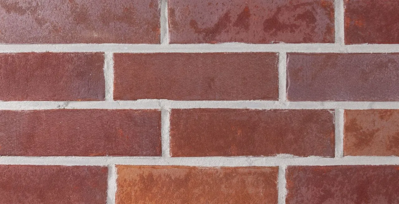 Spaltriemchen Kupfer rot-bunt Produktbild frontal Spaltriemchen Kupfer rot bunt. Das Klinkerriemchen hat eine glatte rot-bunte Oberfläche und ist nur 14mm stark.
