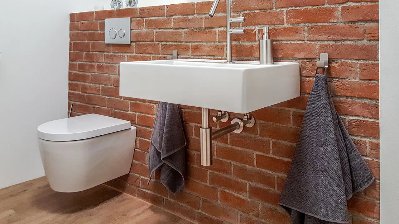 Ziegelwand im Badezimmer. Die klaren roten Riemchen sehen toll mit den weißen Amaturen aus. Die Riemchen sind hell verfugt und schaffen so einen tollen übergang zur weißen wand. ein echter blickfang