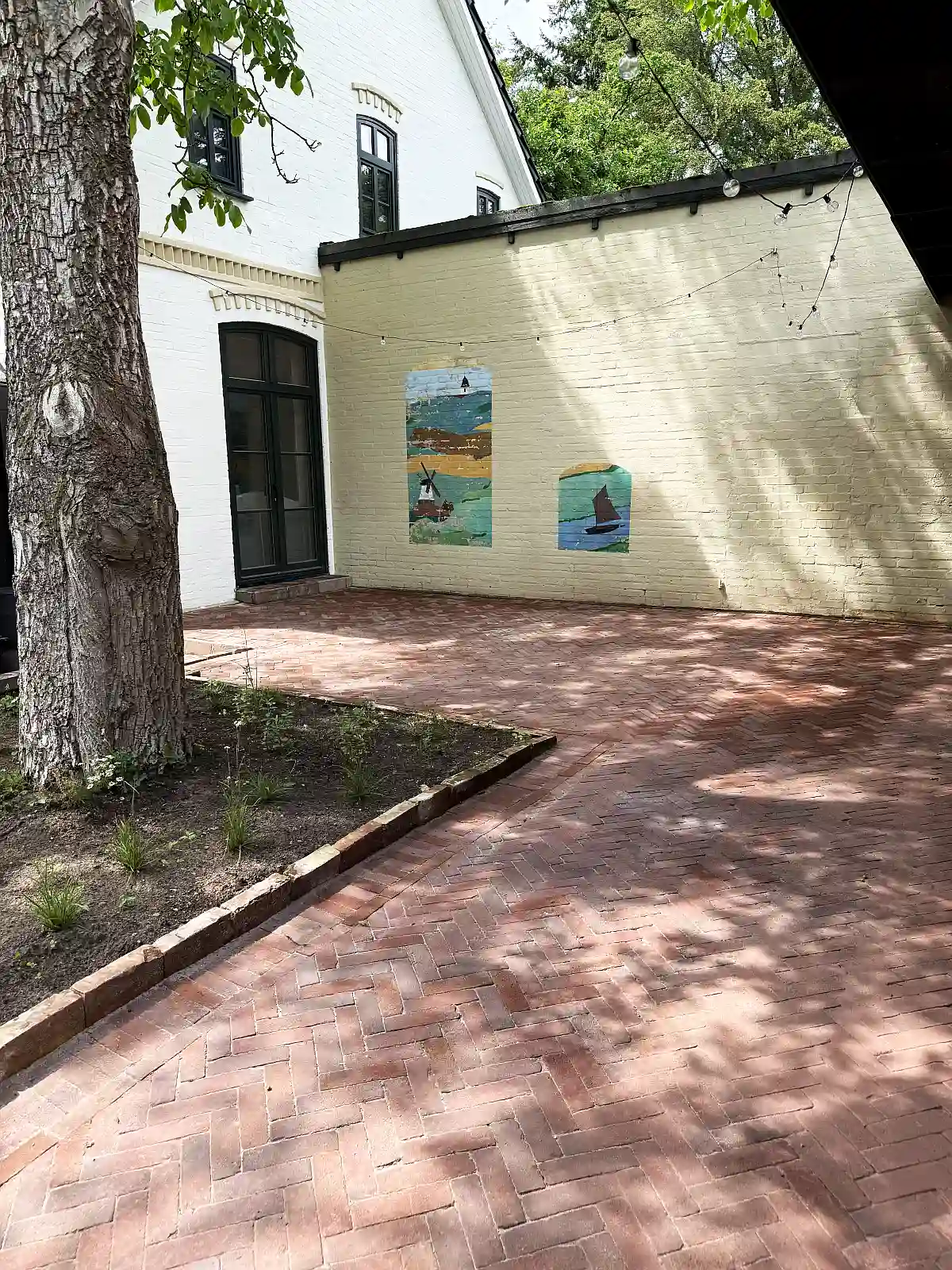 Ein Innenhof mit einem roten Pflasterklinker auf einer Terrasse verlegt.