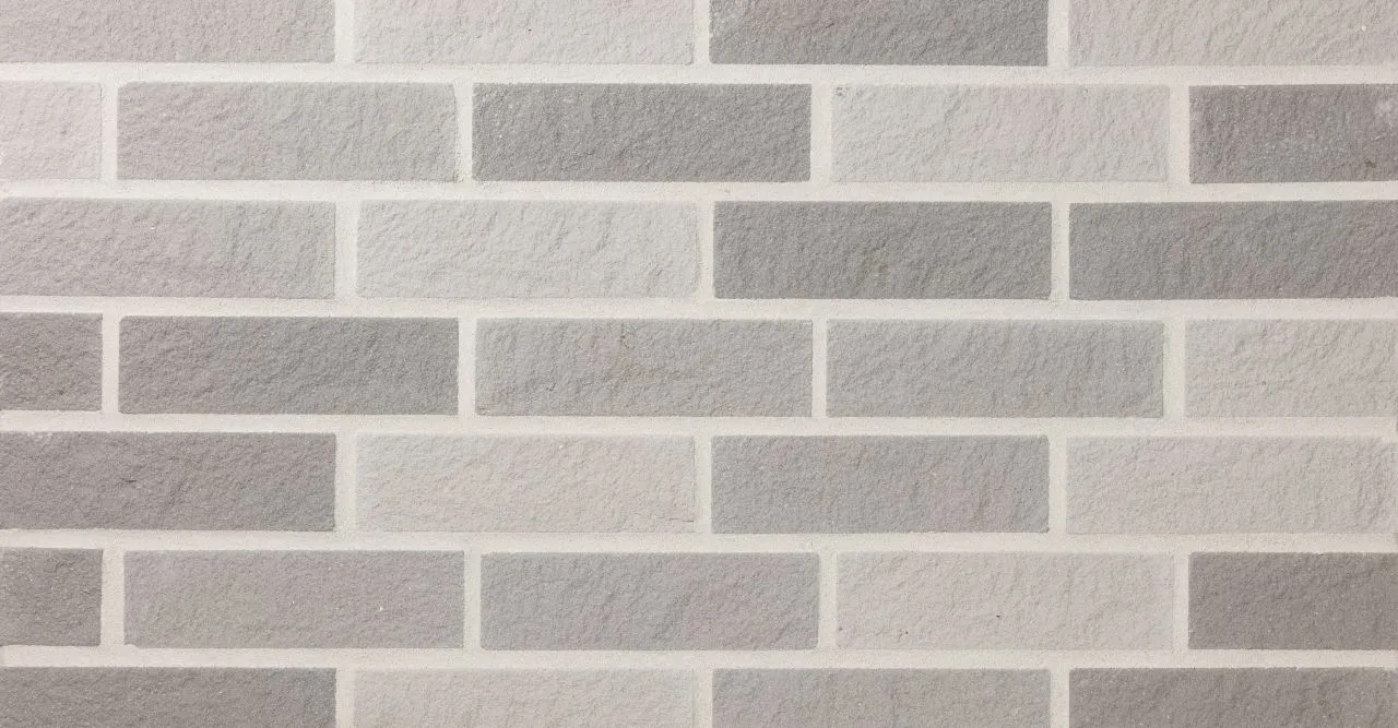 Kalksandstein Riemchen wolkengrau hellgrau grau in frontaler Ansicht mit weissen Fugen